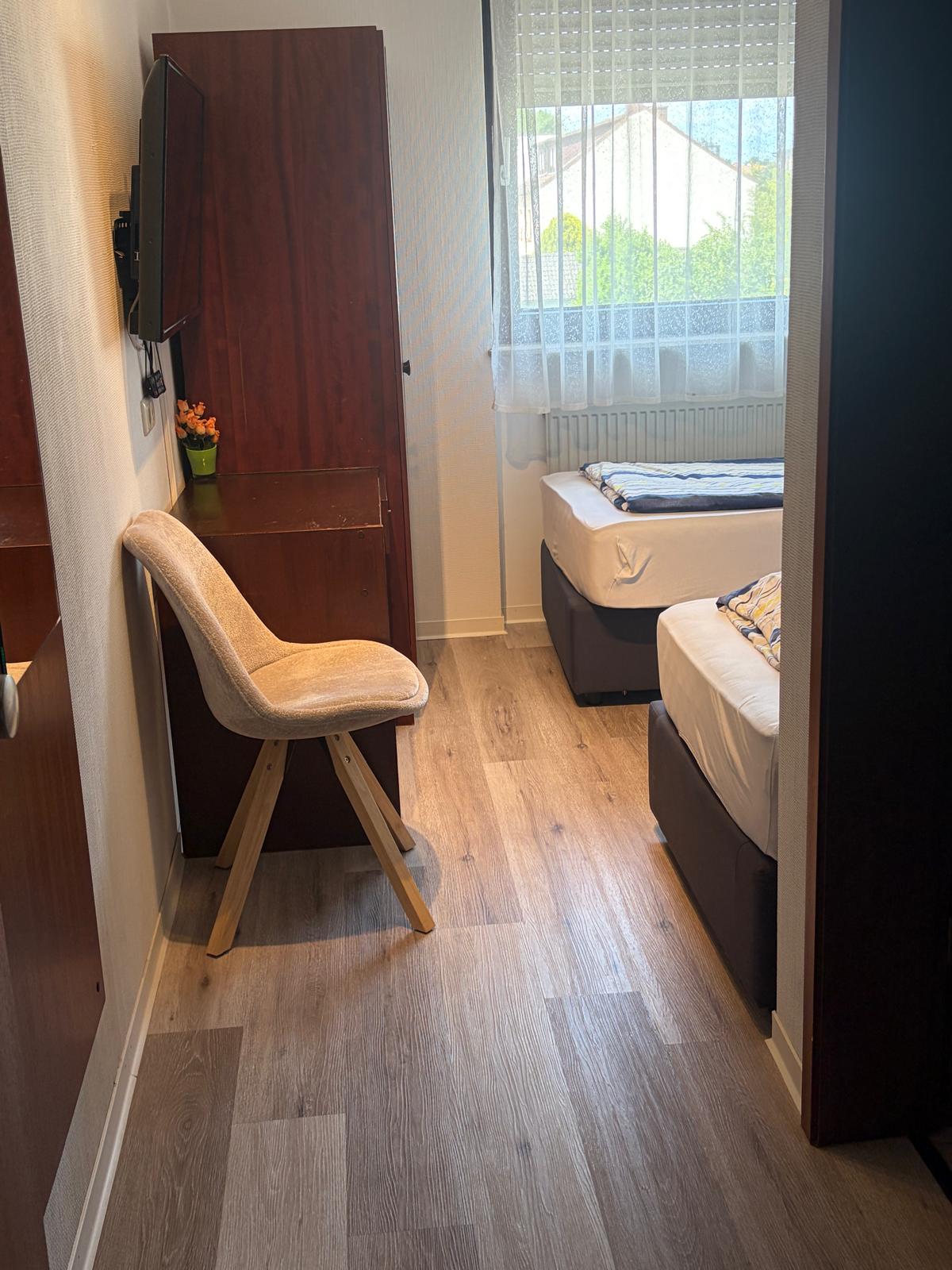 Twin room with wardrobe and television at Hotel Weller Mühlheim am Main