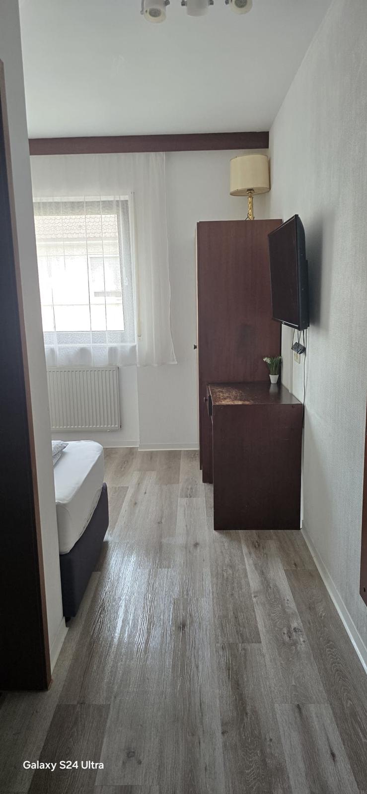 Room with wardrobe and television at Hotel Weller Mühlheim am Main